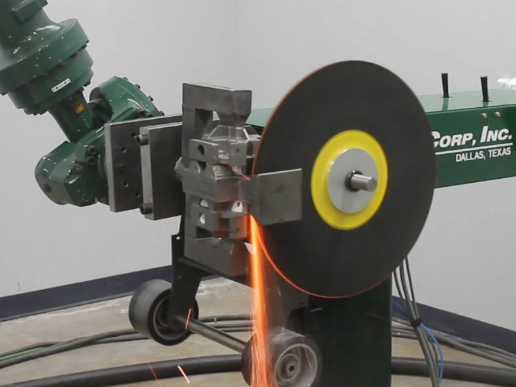 robot handling part agaisnt a metal saw to cutoff metal casting